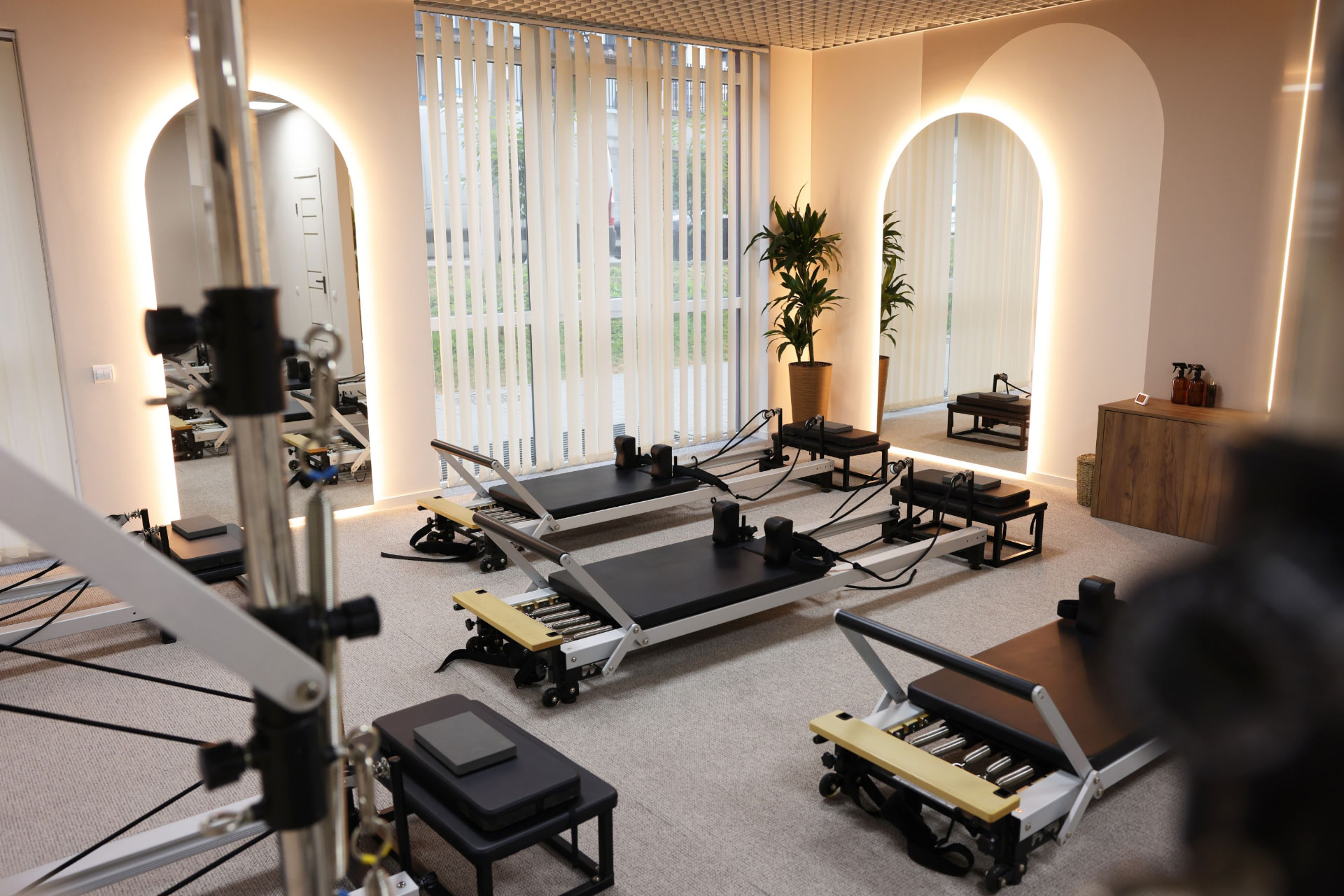 Petit studio de Pilates avec quatre Reformers, grands miroirs et fenêtre lumineuse
