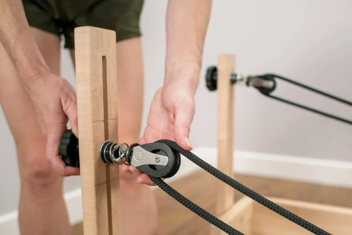 Réglage d’une corde et d’une poulie sur un Reformer en bois